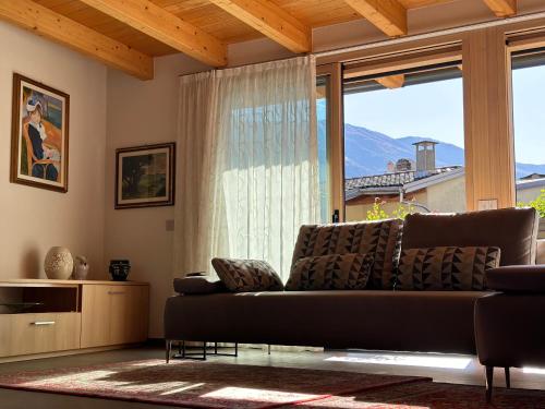 a living room with a couch and a large window at Casa Delfina in Grosotto