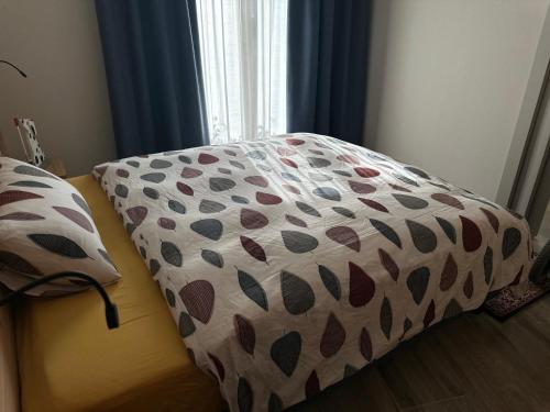 a bed with a cover on it with a window at Casa Delfina in Grosotto