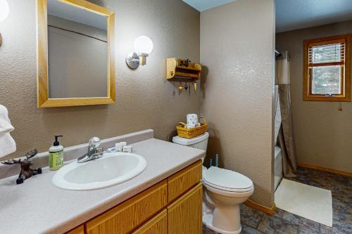 a bathroom with a sink and a toilet and a mirror at Seasons Pass in Eagle River