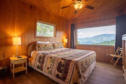 ガトリンバーグにあるBeautiful 4 bedroom chalet with million dollar viewsのベッドと大きな窓のある寝室