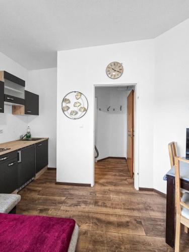 a living room with a kitchen and a clock on the wall at studio apartment for 2 in Stockerau