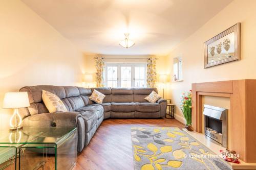 a living room with a couch and a fireplace at Violetta Hemsby - Holiday home with Games Room in Hemsby