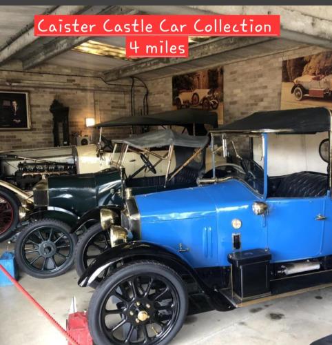 a group of old cars parked in a garage at Violetta Hemsby - Holiday home with Games Room in Hemsby