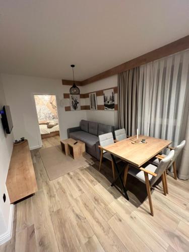 a living room with a table and a couch at Villa Mont in Jahorina