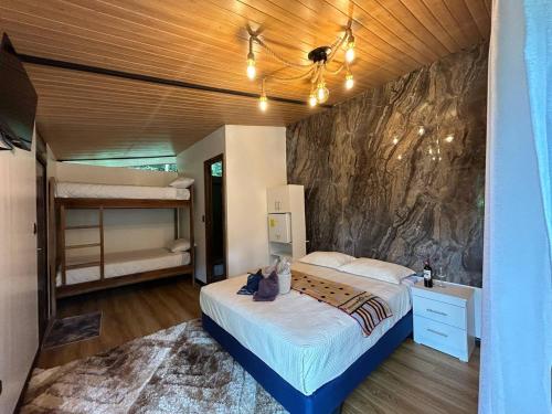 a bedroom with a bed and a rock wall at Hostería RIVER PARADISE in Río Negro