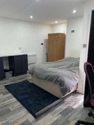 een slaapkamer met een bed, een bureau en een stoel bij Cosy studio in Queensbury