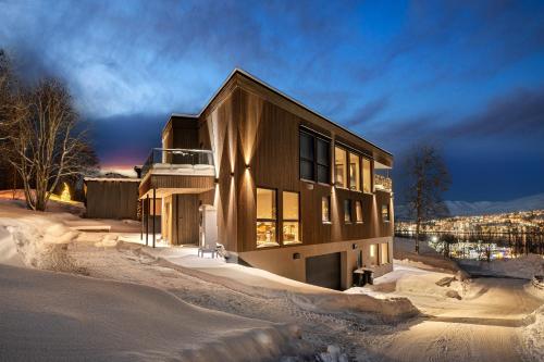 a house in the snow at night at ARCTIC HOMES - The View in Tromsø