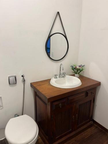 a bathroom with a sink and a toilet and a mirror at Recanto dos Vianas in Teresópolis