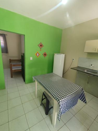 a kitchen with a table and a green wall at Pousada Panorama do Mar in Fortaleza