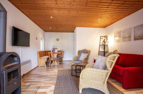 a living room with a red couch and a table at Ferienhaus MöwenNest mit Garten und Kamin in Silz