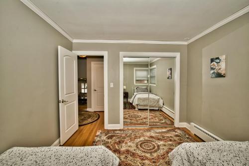 a room with two beds and a hallway with a mirror at Madison House in Skokie