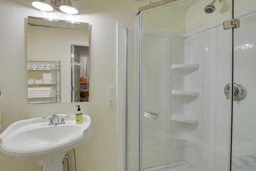 a white bathroom with a sink and a shower at Walk to Harbor Pet-Friendly Apt in Sorrento! in Sorrento