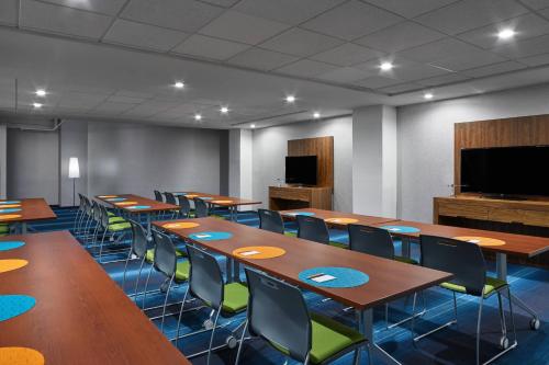 a conference room with tables and chairs and a flat screen tv at Aloft Houston Downtown in Houston