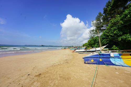 a beach with several boats sitting on the sand at La Dolce Vita Weligama in Weligama
