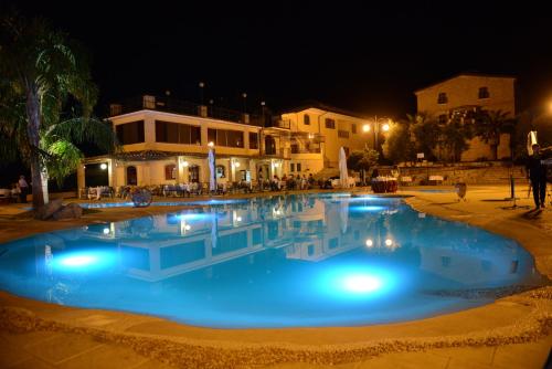 a large pool with blue water at night at Relais Il Mulino in Corigliano Calabro