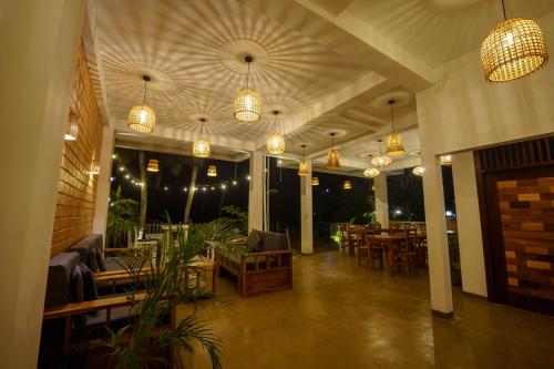 a restaurant with tables and chairs and pendant lights at La Dolce Vita Weligama in Weligama