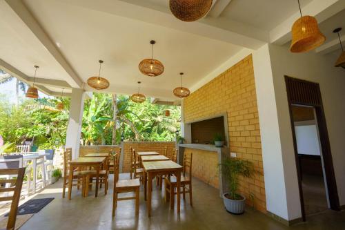 a restaurant with wooden tables and chairs and lights at La Dolce Vita Weligama in Weligama