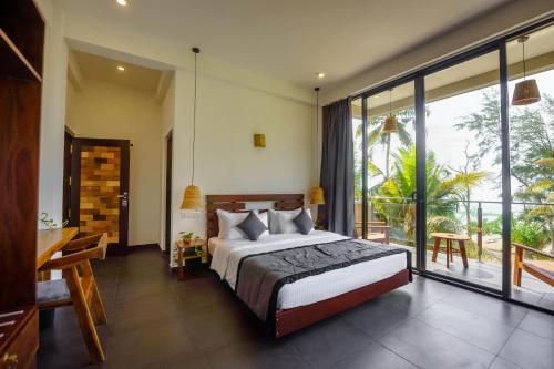 a bedroom with a bed and a balcony at La Dolce Vita Weligama in Weligama