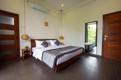 a bedroom with a large bed and a sliding glass door at La Dolce Vita Weligama in Weligama