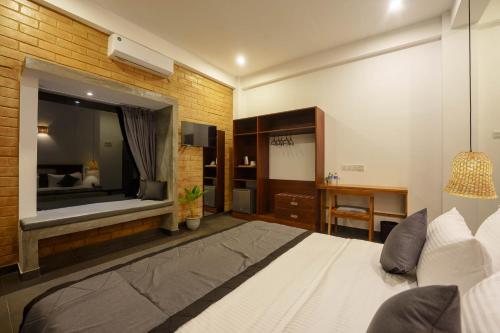 a bedroom with a white bed and a large mirror at La Dolce Vita Weligama in Weligama