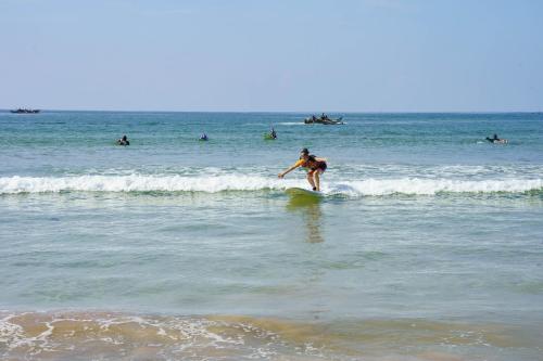 a man riding a wave on a surfboard in the ocean at La Dolce Vita Weligama in Weligama