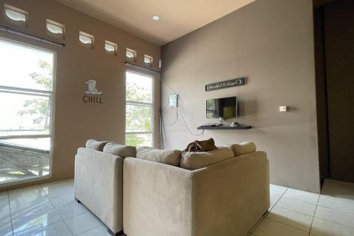 a living room with a couch in front of a window at VK Pods Pangandaran in Pangandaran