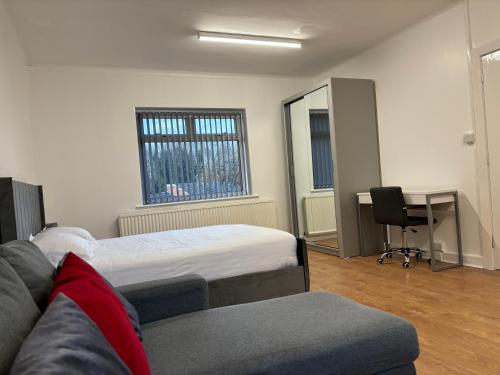 a room with a bed and a couch and a desk at Del Apartments in Warrington
