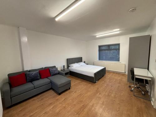 a living room with a couch and a bed at Del Apartments in Warrington