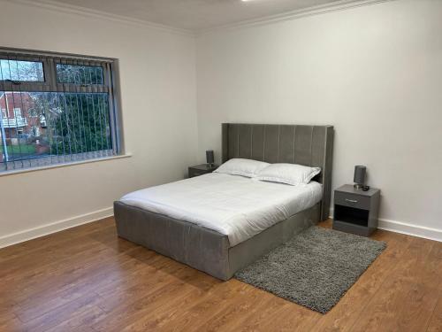 a bedroom with a large bed and a window at Del Apartments in Warrington