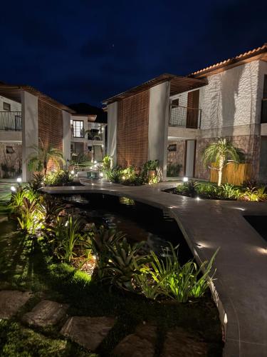 an exterior view of a building with a pond at night at Apto Nanto in Mucugê