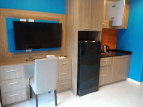 a kitchen with a black refrigerator and a white chair at 泰国芭提雅中天豪华酒店公寓近海滩 in Pattaya South
