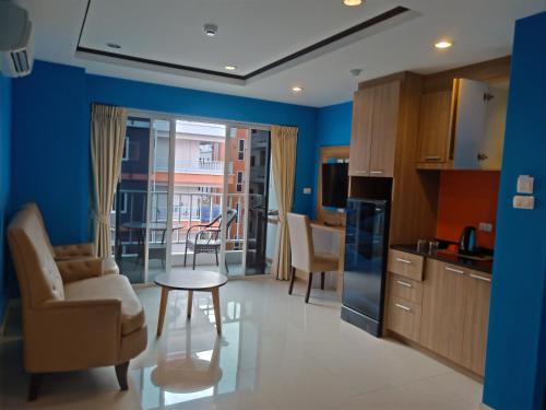 a kitchen with blue walls and a table and chairs at 泰国芭提雅中天豪华酒店公寓近海滩 in Pattaya South