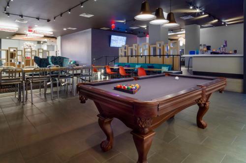 a pool table in a room with tables and chairs at Aloft El Paso Downtown in El Paso