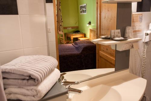 bagno con lavandino, servizi igienici e specchio di Hôtel La Garenne a Labeaume