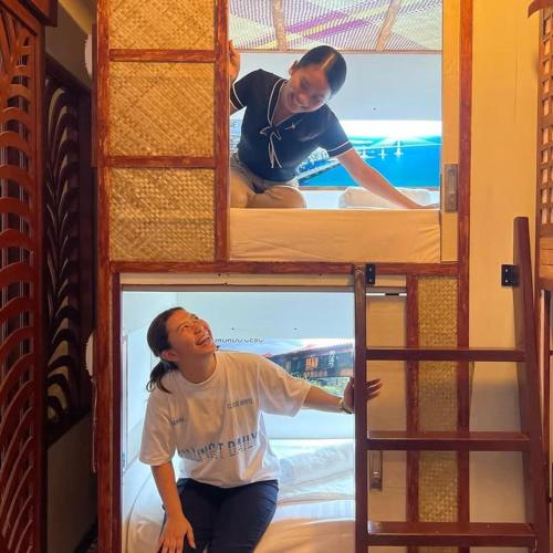 a man sitting on top of a bunk bed at Balai Balai Capsule Hotel Cebu in Cebu City