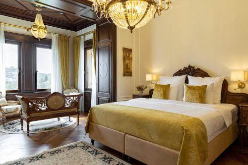 a bedroom with a large bed and a chandelier at Schloss Lieser, Autograph Collection in Lieser