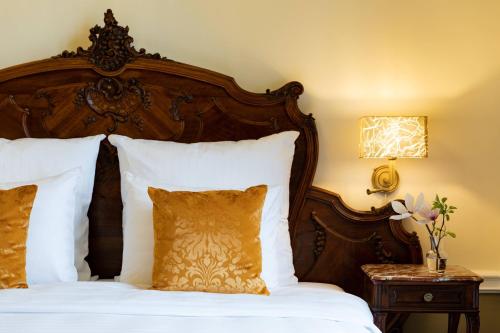 a bedroom with a wooden bed with white pillows at Schloss Lieser, Autograph Collection in Lieser