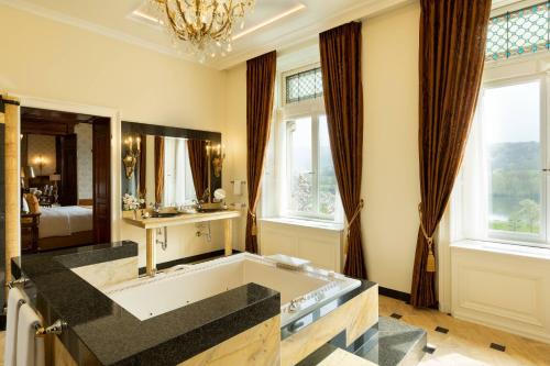 a bathroom with a tub and a large mirror at Schloss Lieser, Autograph Collection in Lieser