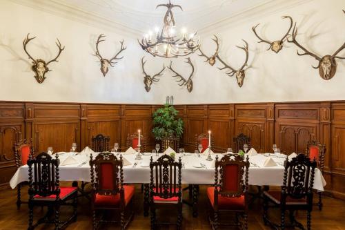 a dining room with a table and antlers on the wall at Schloss Lieser, Autograph Collection in Lieser