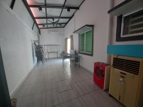 a living room with a table and chairs in a room at Comfort homestay68 in Sitiawan