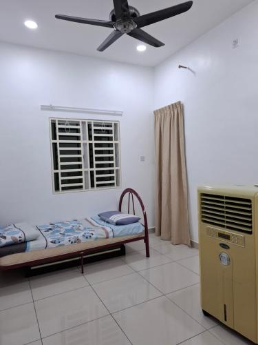 a bedroom with a bed and a ceiling fan at Comfort homestay68 in Sitiawan