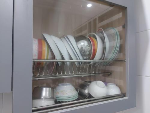 a cabinet filled with plates and bowls and dishes at Comfort homestay68 in Sitiawan