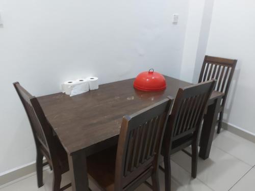 a wooden table with chairs and a red apple on it at Comfort homestay68 in Sitiawan