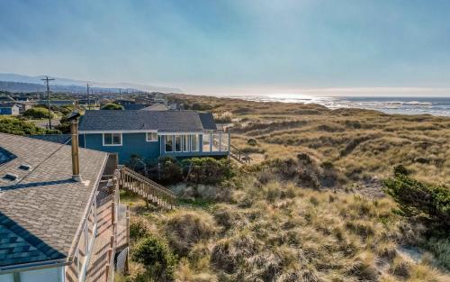 a blue house on the beach with the ocean at Oceania House in Waldport