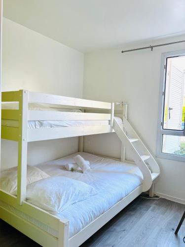 - un lit superposé blanc avec un ours en peluche sur la couchette inférieure dans l'établissement La Vallée des Lumières - 5 minutes de Disneyland, à Magny-le-Hongre