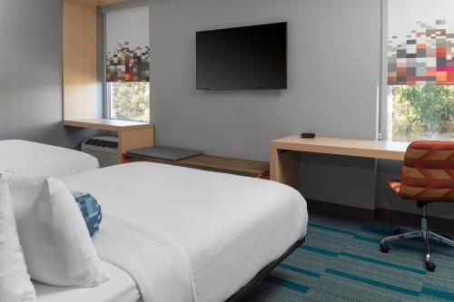 a hotel room with two beds and a desk with a computer at Aloft Gainesville University Area in Gainesville