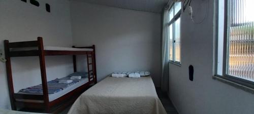 a bedroom with two bunk beds and a window at Flat Lua Crescente - Pituba II no coração da vila caminho das praias in Itacaré
