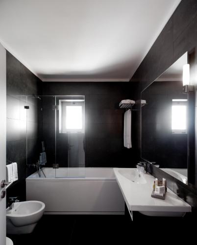 a bathroom with a tub and a sink and a bath tub at Furadouro Boutique Hotel Beach & SPA in Ovar