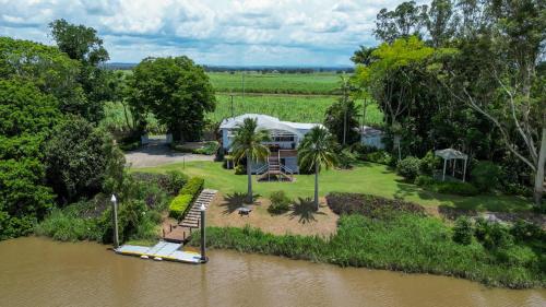an aerial view of a house next to a river at Clarence River Retreat - Oceanstays - Farmstay & Jetty in Lawrence