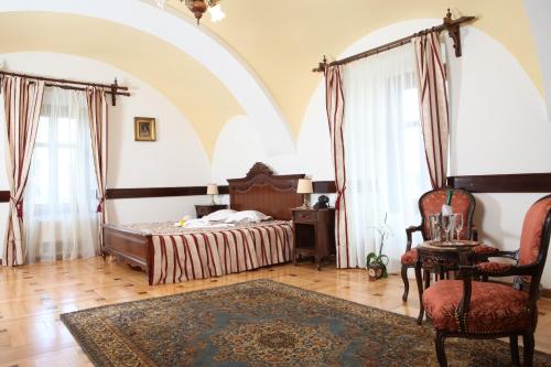 a bedroom with a bed and a chair at Castel Haller in Ogra